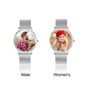 May include: Two silver watches with mesh bands. The watch faces display personalized photos. One watch has a photo of a man with a dog, and the other has a photo of a young girl wearing a red hat. The text "Male" and "Women's" are below each watch.