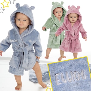 May include: Three baby robes in different colours: light blue, green, and pink. Each robe has a hood with ears and a personalised name embroidered on the front. The names are Noah, Leo, and Ella.