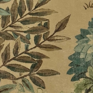 May include: A beige fabric with a floral pattern featuring brown leaves and blue and green flowers.