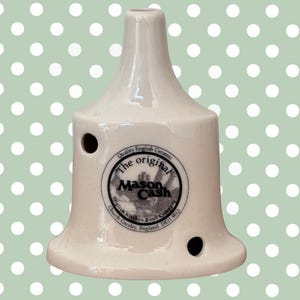 Può includere: Coperchio per ciotola da cucina in ceramica bianco sporco con due fori. Il coperchio ha una base svasata e una parte superiore affusolata. Il testo "The original Mason Cash" è stampato sul davanti. Prodotto in Inghilterra.