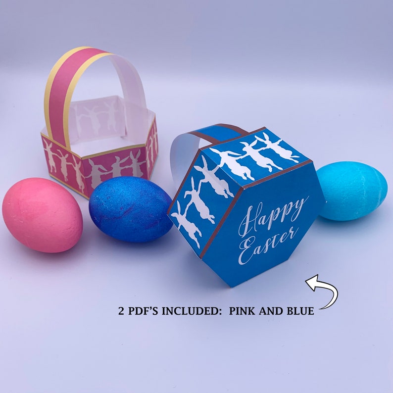 May include: Two printable Easter baskets, one pink and one blue, with a bunny rabbit design and the text "Happy Easter". The baskets are shown with three Easter eggs.