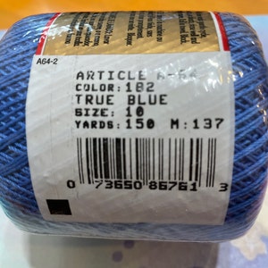 May include: A blue ball of yarn with a white label that says "ARTICLE A-64 COLOR: 182 TRUE BLUE SIZE: 10 YARDS: 150 M: 137" and a barcode. The label also has the number "A64-2" on it.