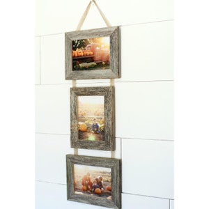 May include: A set of three rustic wood picture frames with twine hanging them on a white wall. The frames are arranged vertically with a photo of a red truck in the top frame, a photo of two children in the middle frame, and a photo of three children in the bottom frame.
