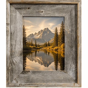 May include: A framed landscape print featuring a mountain range reflected in a calm lake. The artwork is set within a rustic, weathered wooden frame. The scene includes evergreen trees and a sky with soft, warm colors.