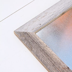 May include: A rustic wooden frame with a light gray, textured, metal insert. The frame has a distressed, whitewashed finish.