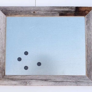 May include: A rustic wooden framed magnetic dry erase board with four black magnets attached to the surface.