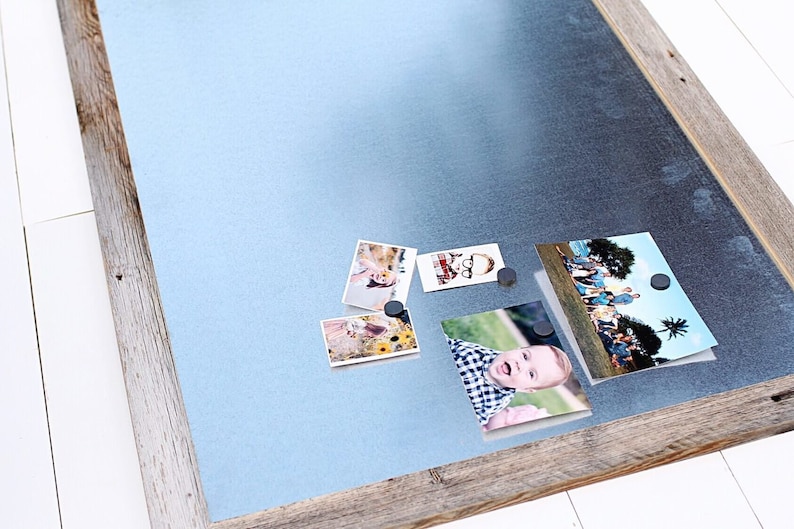 May include: A rustic wooden framed magnetic board with a light blue metal surface.  Four photos are attached to the board with magnets.
