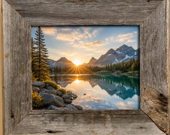 May include: A framed landscape photograph of a mountain lake at sunset. The image features a vibrant sunset with sun rays, a calm lake reflecting the mountains, and a rustic wooden frame.