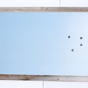 May include: A light blue magnetic dry erase board with a rustic wood frame. The board has four black magnetic dots on it.