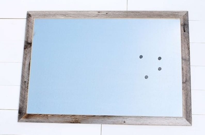 May include: A light blue magnetic dry erase board with a rustic wood frame. The board has four black magnetic dots on it.