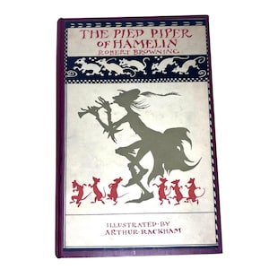 May include: A vintage book cover with a red spine and a cream-colored front cover. The title is "The Pied Piper of Hamelin" by Robert Browning. The cover features an illustration of a man playing a pipe, surrounded by rats.