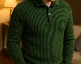 May include: A dark green ribbed knit sweater with a collared neckline and three button closure. The long-sleeved sweater is worn with blue jeans. The person is standing indoors with their hands in their pockets.