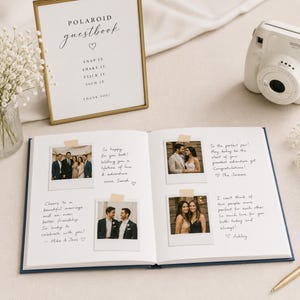 May include: A guestbook with an open page displaying four Polaroid-style photographs attached with tape, each accompanied by handwritten notes. A gold-framed sign reads Polaroid guestbook, snap it, shake it, stick it, sign it, thank you.