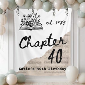 Può includere: Banner bianco con la scritta "Chapter 40" e "Katie's 40th Birthday". Lo striscione presenta anche la scritta "est. 1985" e un'illustrazione floreale sopra un libro aperto. Palloncini bianchi e verdi sullo sfondo.