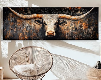May include: A longhorn painting with a brown and white color scheme hangs on a white wall. The artwork is above a woven chair and a round rug. Cacti in pots are on either side of the chair.