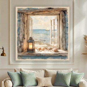 May include: A framed painting shows an open window with a view of the sea and a sailboat. A lit lantern and seashells are on the windowsill. The painting is above a beige sofa with green and beige cushions, and a white rug.