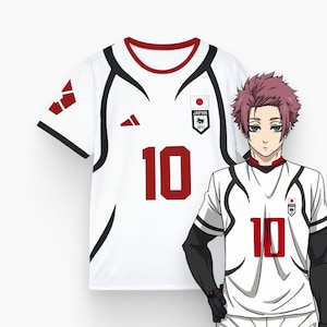 Può includere: Maglia da calcio bianca con dettagli neri e rossi, con il numero 10 in rosso. La maglia presenta il logo Japan JFU e un colletto rosso. Viene mostrato anche un personaggio anime con una maglia simile.
