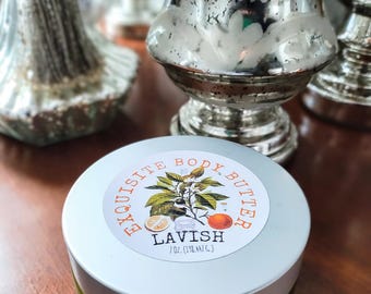 May include: A white jar with a green lid and a white label that says "Exquisite Body Butter" with a drawing of a citrus tree and the words "LAVISH 7 oz. (198 ml.)"