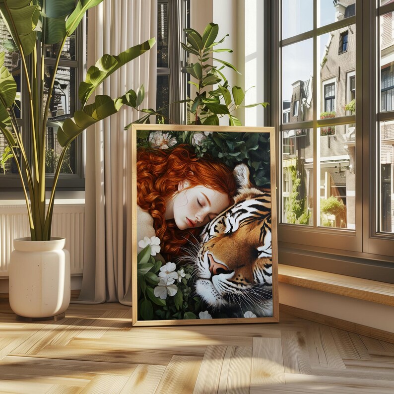 May include: A framed painting of a woman with long red hair sleeping next to a tiger. The woman is wearing a white dress and the tiger is looking at the viewer. The painting is set in a lush green forest with white flowers.