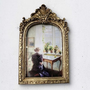 Mujer leyendo enmarcada: marco de arco dorado ornamentado, pintura de escena interior vintage