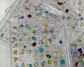 100+ Mixed Nail Rhinestones in a 64-Grid Acrylic Display Case