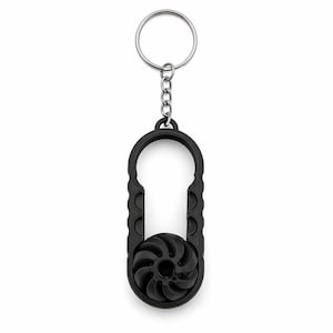 Puede incluir: Un llavero abridor de botellas negro con un llavero plateado. El abridor tiene un diseño único con un agarre texturizado y un elemento en forma de espiral. Hecho de plástico, está diseñado para abrir botellas.