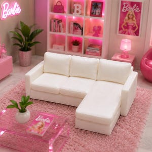 Puede incluir: Un sofá seccional blanco con chaise longue, colocado sobre una alfombra de pelo largo rosa. El sofá cuenta con tres cojines de respaldo y una sección de asiento larga. Es parte de un conjunto de sala de muñecas con muebles rosa y decoración Barbie.