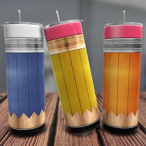 May include: Three stainless steel tumblers with a pencil design. The tumblers are blue, yellow, and orange. Each tumbler has a black band around the middle and a brown wood-like base.