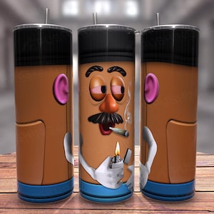 Peut inclure: Un gobelet brun et noir avec une image de dessin animé d'un personnage de tête de pomme de terre fumant une cigarette et tenant un briquet. Le personnage a une moustache et une expression surprise. Le gobelet a une bande bleue autour du bas.