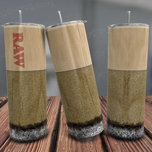 May include: Three stainless steel tumblers with clear straws. The tumblers have a brown paper-like top and a green and brown textured lower half. The word "RAW" is printed in red on one of the tumblers.