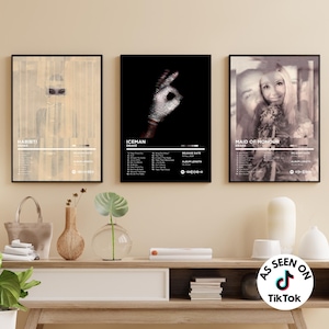 May include: Three framed wall art prints featuring Drake album covers titled Habibi, Iceman, and Maid of Honour. Each print displays a tracklist, release date, album length, and a Spotify code. The posters are displayed in black frames on a wall.