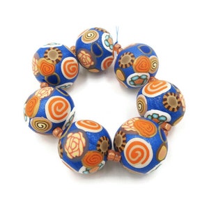 May include: A bracelet made of blue and orange patterned beads. The beads are round and have a glossy finish.
