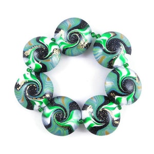 May include: A bracelet made of round, green, white, and black swirl patterned beads with gold flecks.
