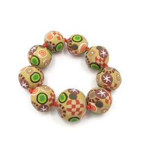 May include: A bracelet made of round, beige beads with colorful geometric patterns. The beads are connected with red string.