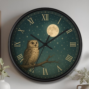 Puede incluir: Un reloj de pared redondo con marco negro. La esfera del reloj presenta un fondo verde azulado con una luna llena y estrellas. Un búho está posado en una rama. Los números romanos marcan las horas. Las manecillas del reloj son negras.