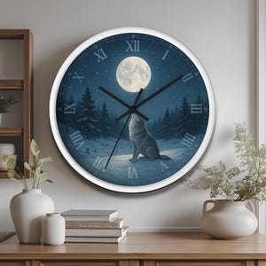 Puede incluir: Un reloj de pared redondo con marco blanco. La esfera muestra una escena nocturna con luna llena, un lobo aullando y un bosque. Los números romanos marcan las horas, y las manecillas negras indican la hora.
