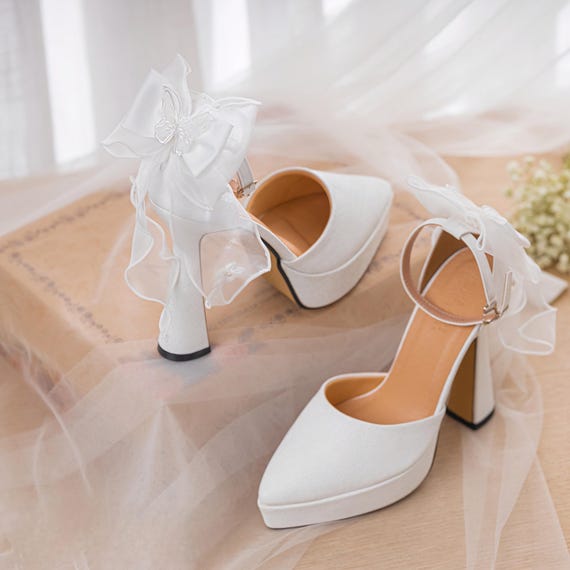 Elegantes tacones blancos de boda con lazo en el tobillo, zapatos