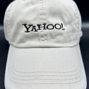 May include: A beige baseball cap with black embroidery that reads "YAHOO!"