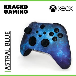 Puede incluir: Un mando Xbox azul y negro con un diseño de temática galáctica. El mando tiene el texto "XBOX" impreso.