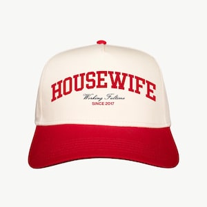 May include: White and red baseball cap with the text "HOUSEWIFE Working Fulltime SINCE 2017" in red.