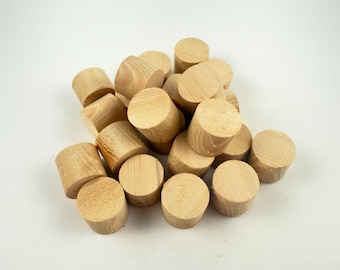 Peut inclure: Un tas de chevilles en bois non finies, de couleur claire. Ces chevilles cylindriques ont un dessus et un dessous plats et sont faites de bois naturel. Elles sont probablement utilisées pour la fabrication de meubles ou des projets de menuiserie.