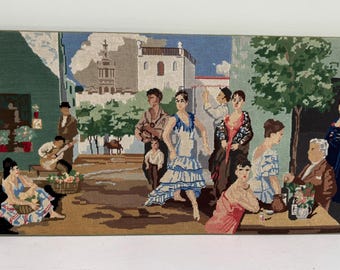 May include: A tapestry depicting a Spanish street scene with figures, including a flamenco dancer in a blue dress. The artwork features a guitarist, people at tables, and a building with a tower. The tapestry has gold tassels.