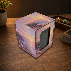 Op de afbeelding: Een vierkante deck box met een bedrukt zonsonderganglandschap met roze bloemen, palmbomen en een kustgezicht. De box heeft een gestructureerde buitenkant, gestikte randen en een grote rechthoekige uitsparing op het voorpaneel.