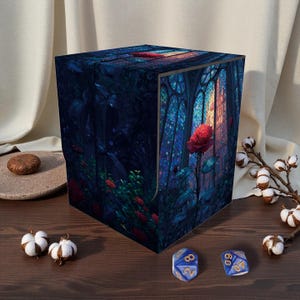 May include: A cube-shaped storage box with a fantasy art design. The artwork depicts a forest scene with a large red rose and stained-glass windows. Two blue dice with gold numbers are in front of the box.