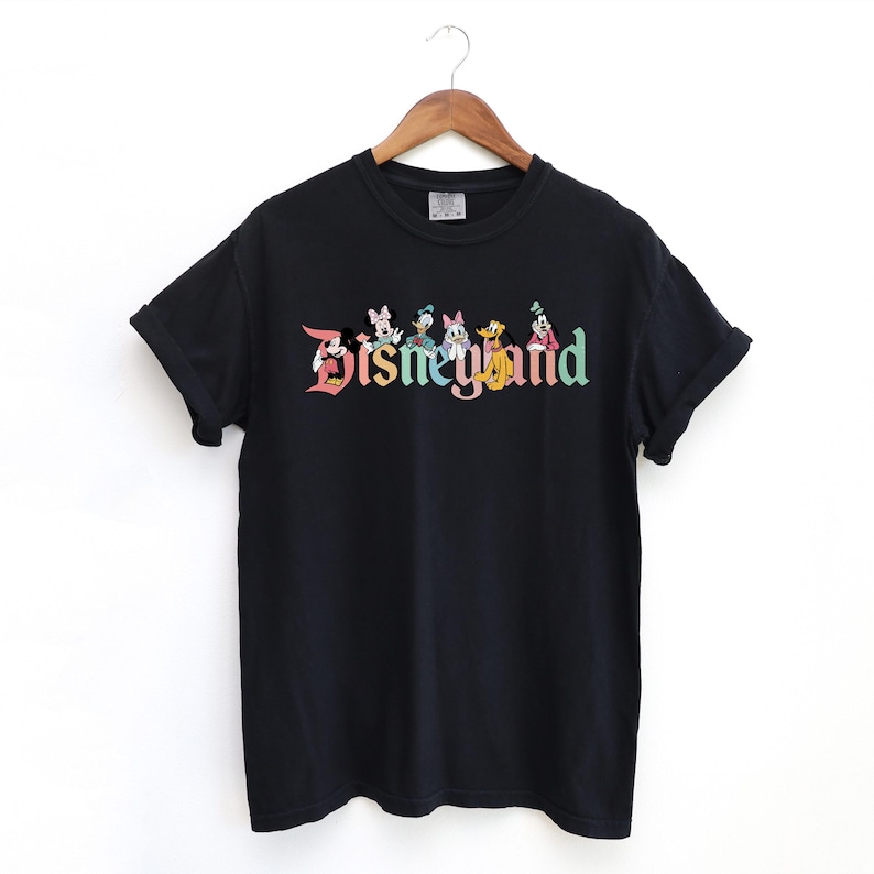 May include: Black t-shirt with a colorful "Disneyland" graphic featuring Mickey Mouse, Minnie Mouse, Donald Duck, Goofy, and Pluto.