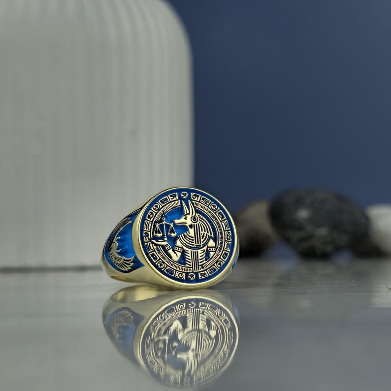 Honor the god of the afterlife with this powerful and refined Anubis ring. Featuring a modern square bezel and decorated with historic Egyptian symbols, this ring represents a deep reverence for cosmic order, spiritual guardianship, and protection. With premium materials and handcrafted excellence, it’s an unforgettable piece of statement jewelry.