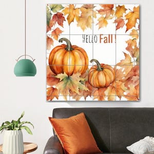 Könnte beinhalten: Ein Aquarellbild von zwei orangefarbenen Kürbissen, die von Herbstblättern umgeben sind. Der Text "Hello Fall!" ist in Schwarz auf weißem Hintergrund geschrieben.