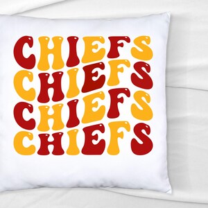 May include: White pillow with the word "CHIEFS" repeated four times in a retro font. The letters are in alternating colors of red and yellow.