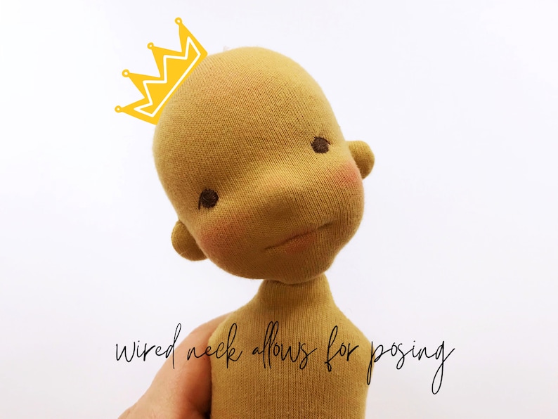 May include: A yellow knitted doll with a wired neck, allowing for posing. The doll has a crown on its head and is wearing a light brown outfit.