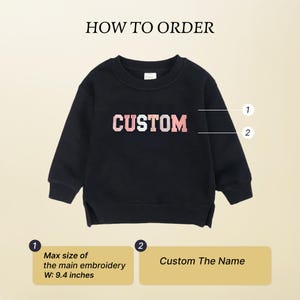May include: Black sweatshirt with the word "CUSTOM" in white and pink lettering. The text "HOW TO ORDER" is at the top. The maximum embroidery size is 23.88 cm wide. The sweatshirt is for custom orders.